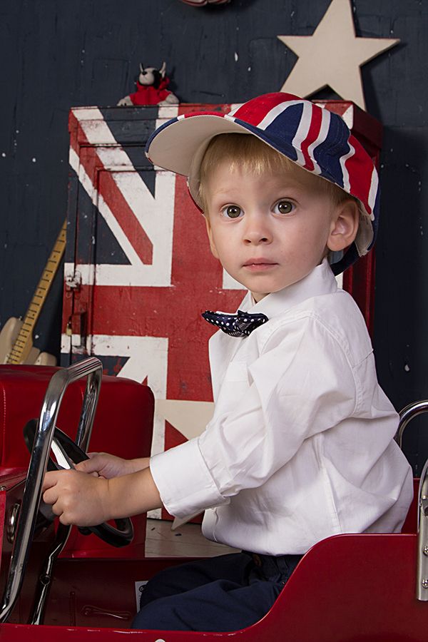 Мальчик на свадьбе в европейском стиле сидит  деткой машинке на фоне Английского флага в белой рубашке с черной бабочкой в белый - фото 2854427 Елена Гильгенберг - фотограф