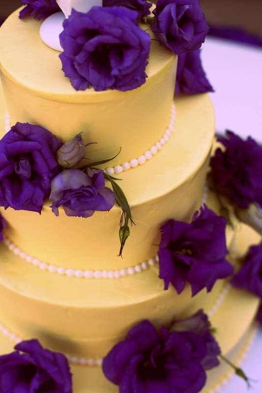 Многоярусный торт желтого цвета, украшен белыми бусами и сиреневыми цветами.   - фото 2874723 Кондитерская "Алтуфьево"