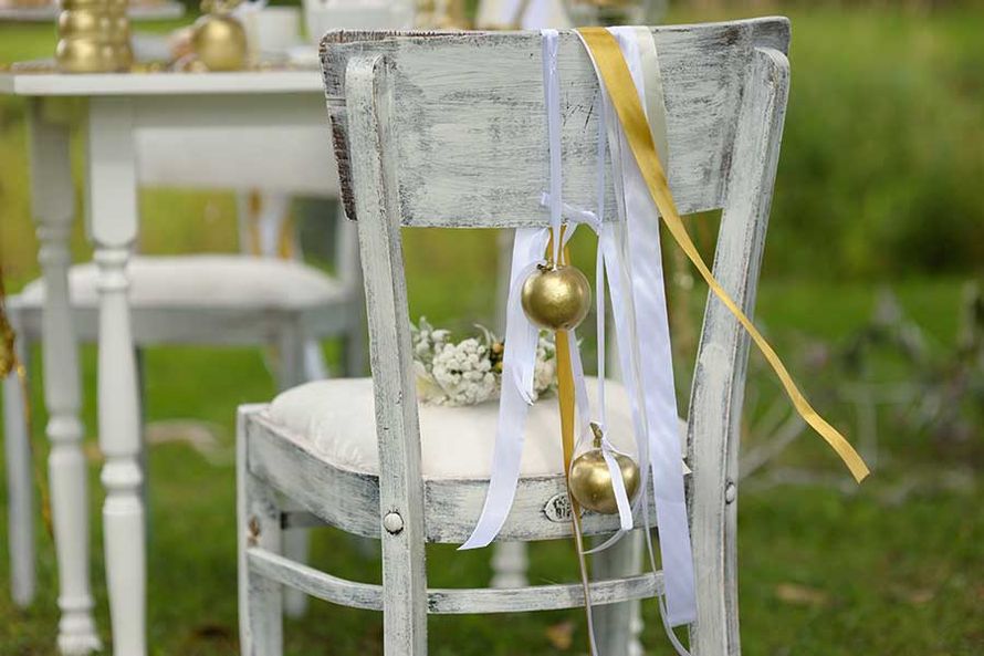Оформление для фотосессии свадьбы с акцентом на золотой цвет с использованием белых деревянных стульев, украшенных лентами, - фото 878413   Студия оформления и декора КриSтиль