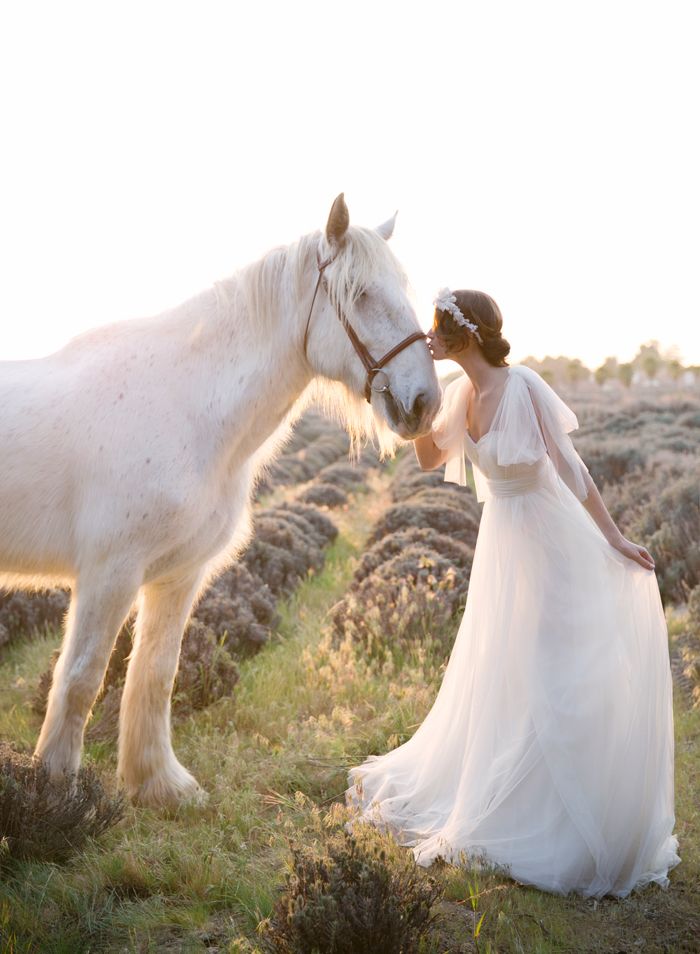 Невеста в белом длинном платье стоит возле белой лошади - фото 3149523 The wedding shop - свадебная студия