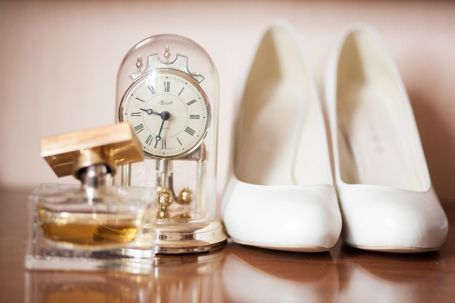 Белые туфли на высоком каблуке рядом с духами и часами.  - фото 1536255 Alexandra765