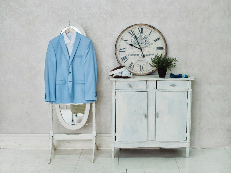 Настенные часы, цветы на белом комоде, синий костюм жениха висит на белом зеркале - фото 1583521 Amazing deco - студия декора 