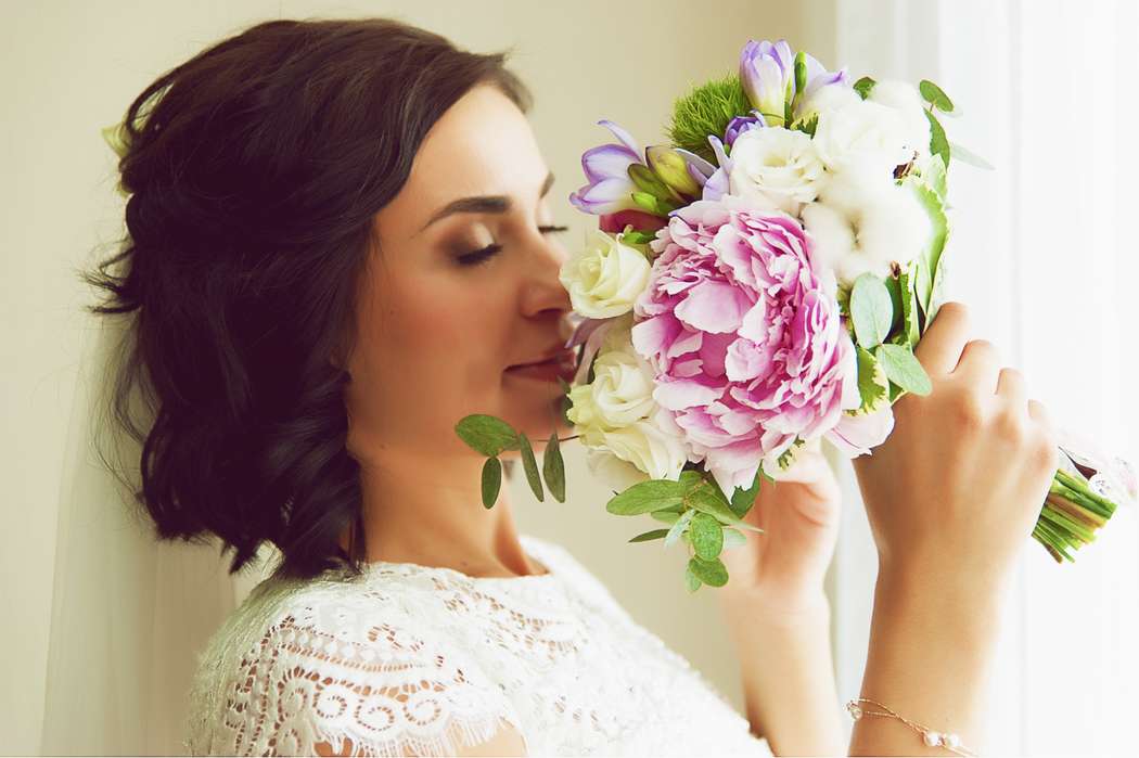 Невеста держит букет из пионов и роз. Ее свадебная прическа в романтическом стиле. В естественном макияже использованы коричневые - фото 3078057 maslo1olya