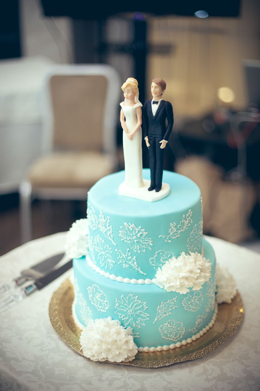 Двухъярусный торт мятного цвета украшен белым кружевом и цветами. на верхнем слое фигурки в виде жениха и невесты. - фото 3276999 Tase4ka