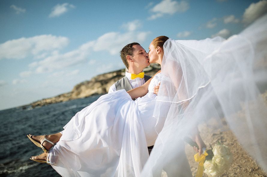 Посреди песчаного пляжа жених поднял невесту  на фоне моря - фото 3404931 Маруська-Маруська