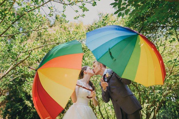 На фоне зелени, жених и невеста целуются под радужного цвета зонтами - фото 3143665 Организатор и выездной регистратор Татьяна Гладких