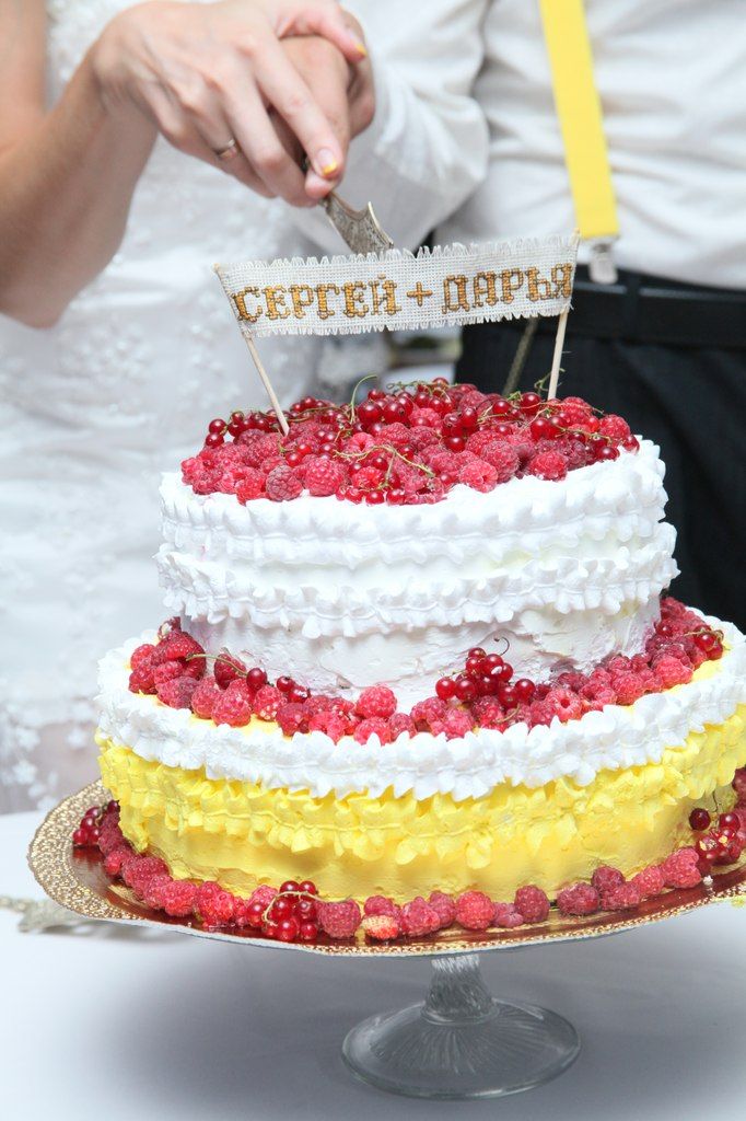 Двухъярусный торт белый с желтым украшенный красными ягодами сверху табличка с именами. - фото 3037367 Птичка_Д