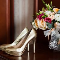 Туфли невесты золотого цвета  и свадебный букет на коричневой столешнице