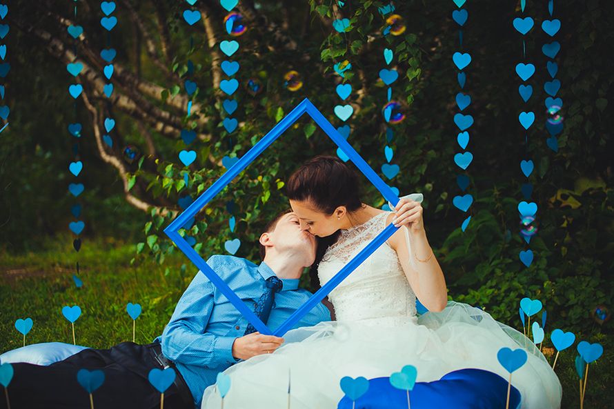 Невеста и жених держат голубой багет среди гирлянд из голубых сердечек  - фото 2333316 MIMM Studio - свадебное агентство