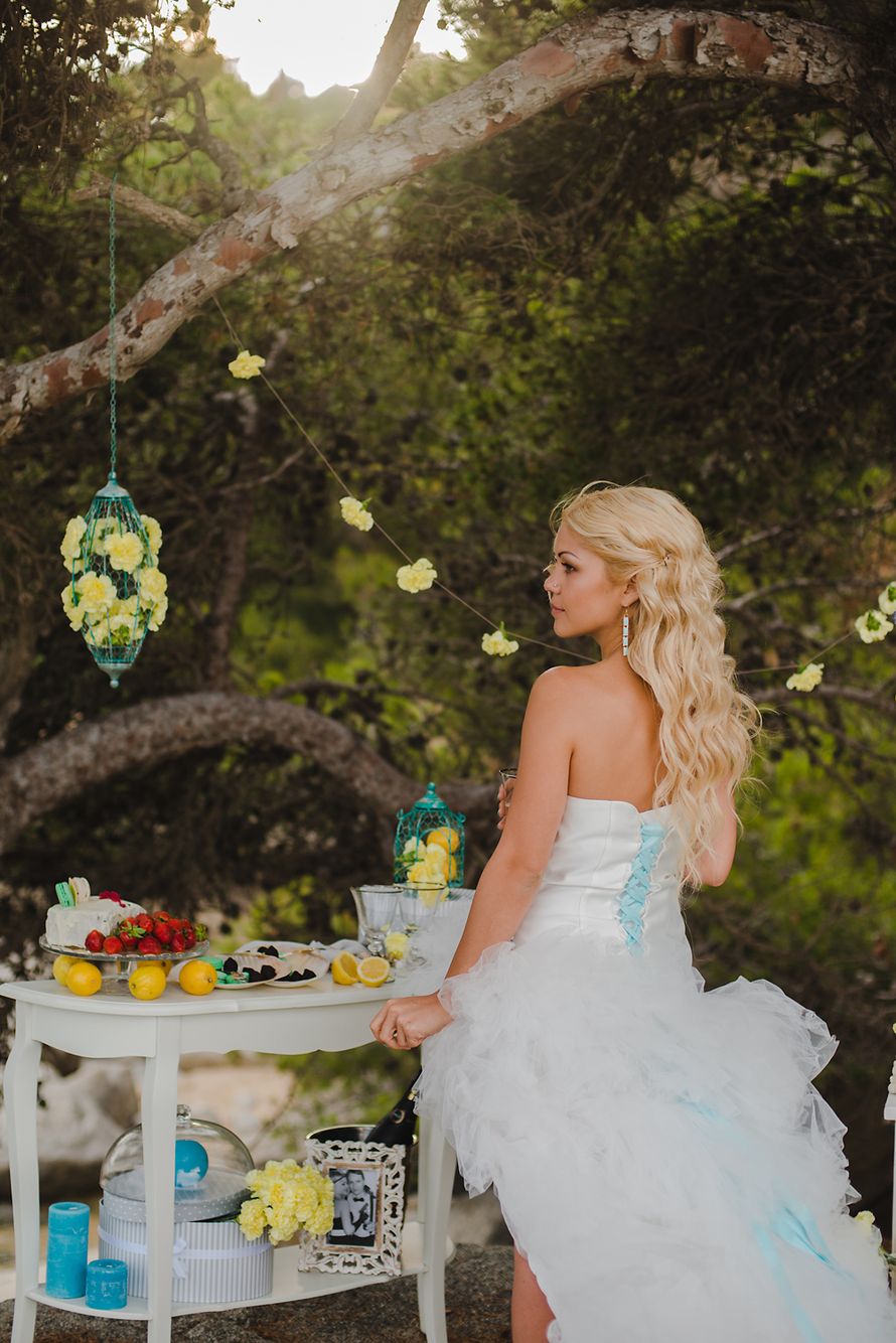 Возле дерева, украшенного гирляндой из жёлтых цветов и цветочным фонариком, рядом с белым столиком стоит невеста - фото 2809367 Свадебное агентство "Джаз"