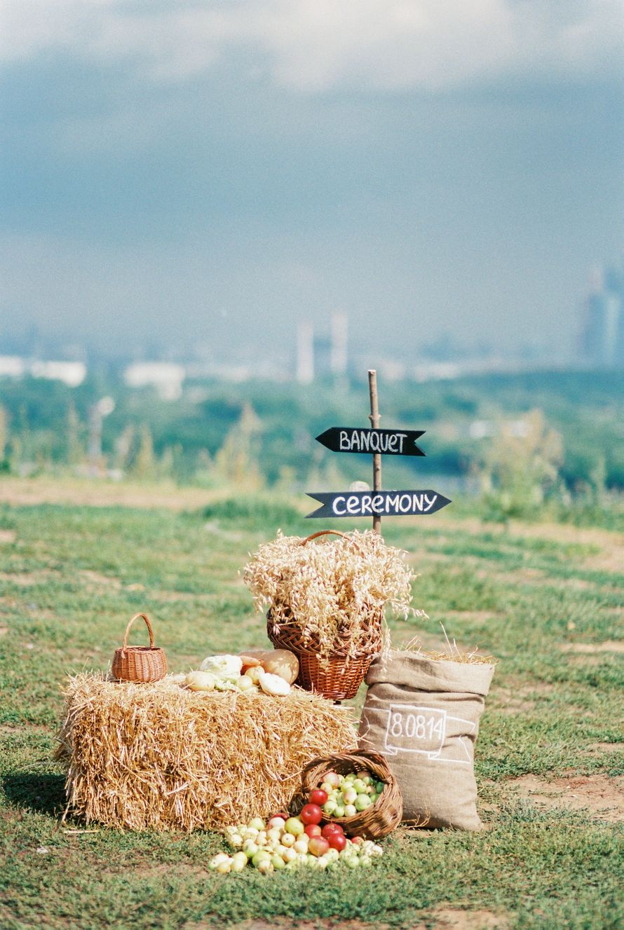 На полянке стоит стог сена, мешок, корзина с колосками пшеницы и указатели направления - фото 3078875 Lovetoflowers - цветочная мастерская
