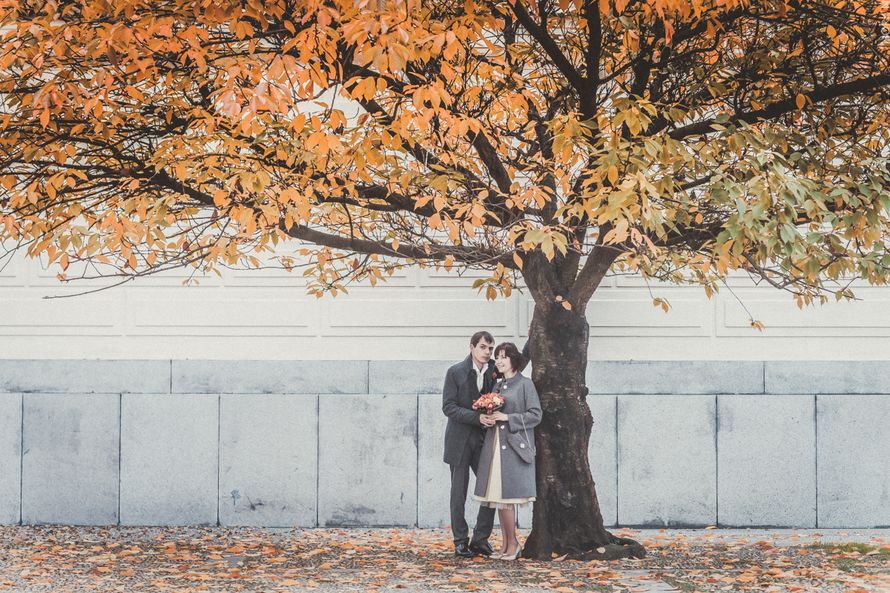 Жених и невеста, прислонившись друг к другу, стоят на фоне белого дома под осенним деревом - фото 3601339 Фотораф Алексей Норкин