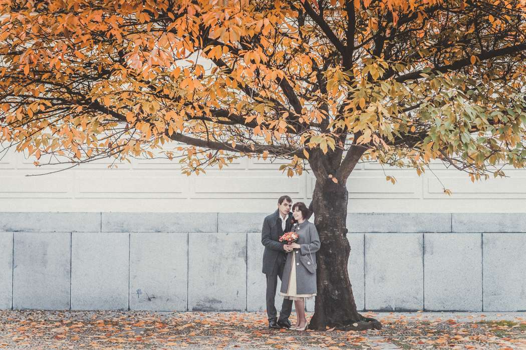 Жених и невеста, прислонившись друг к другу, стоят на фоне белого дома под осенним деревом - фото 3601339 Фотораф Алексей Норкин
