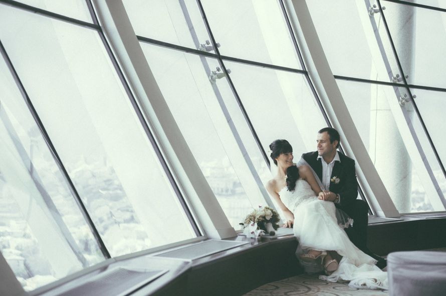 Жених и невеста, прислонившись друг к другу, сидят возле большого окна - фото 3584197 Фотограф Николай Заречнов