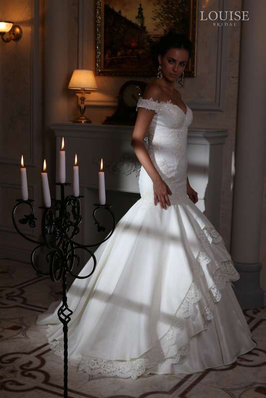 Monika
Эффектное свадебное платье с объемной юбкой из плотной органзы, на которую ярусами настрочена великолепная кайма. Удлиненный лиф, идеально подчеркивающий фигуру, расшит переливающимся кружевом. - фото 4395329 Невеста01