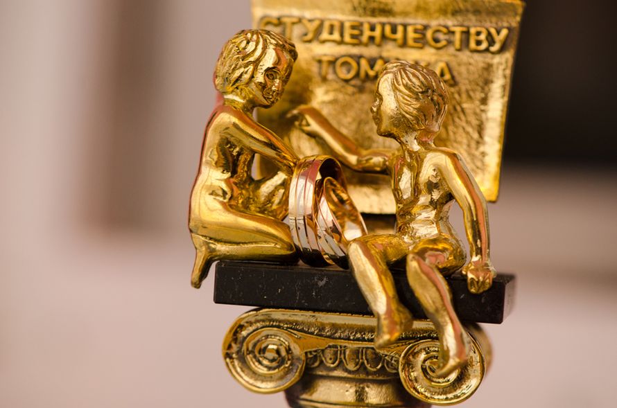 Обручальные кольца из комбинированного золота с бороздками, на фоне статуэтки. - фото 509154 Невеста01