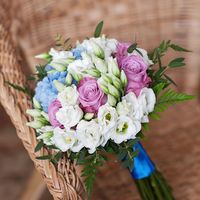 Букет невесты из нежно-голубой гортензии, сиреневых садовых роз, белого лизиантуса, зелени папортника и эвкалипта. Ножка декорирована атласной лентой.