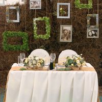 Необычное оформление стены за женихом и невестой тюками сена и  декоративными рамками для фотографий