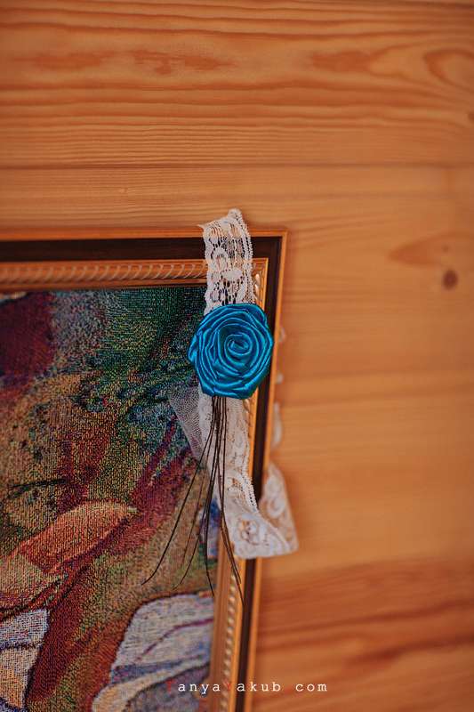 Подвязка белого цвета с голубым цветком висит на картине. - фото 1023065 Capri