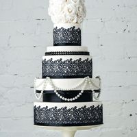 Очень стильный свадебный чёрно-белый торт с жемчужными бусами и сахарным кружевом , с шапочкой из нежных белых роз.