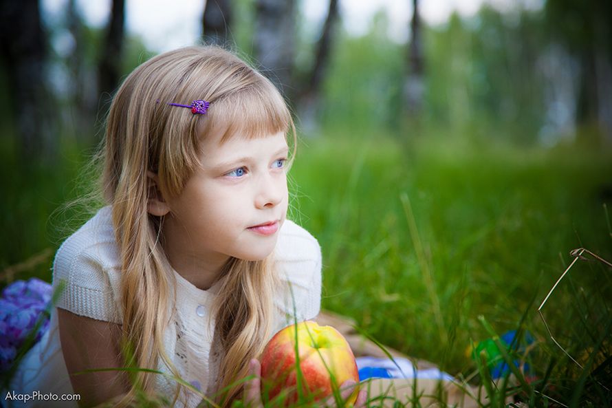 Светлая девочка с яблоком в руке  лежит в лесу на зеленой травке - фото 1324805 Фотографы Анна и Александр Кочеровы