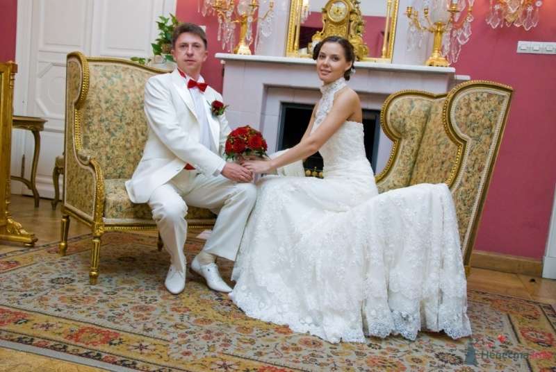 Жених и невеста, взявшись за руки, сидят на креслах у камина - фото 48758 katsonya