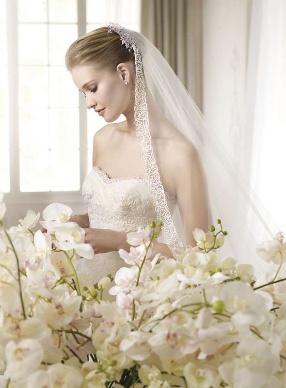 Волосы невесты покрывает лёгкая белая фата с кружевным краем и заколка - фото 980893 Свадебный бутик "Sposa moda"